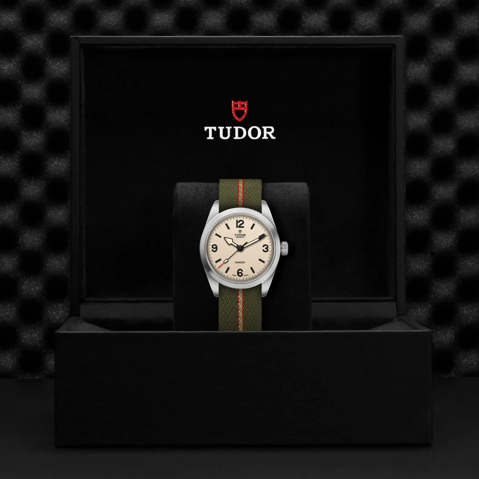 Reloj TUDOR Ranger con esfera beige y correa de tejido verde: presentación en su caja oficial